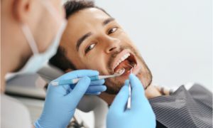 The dentist checks the patient's mouth.